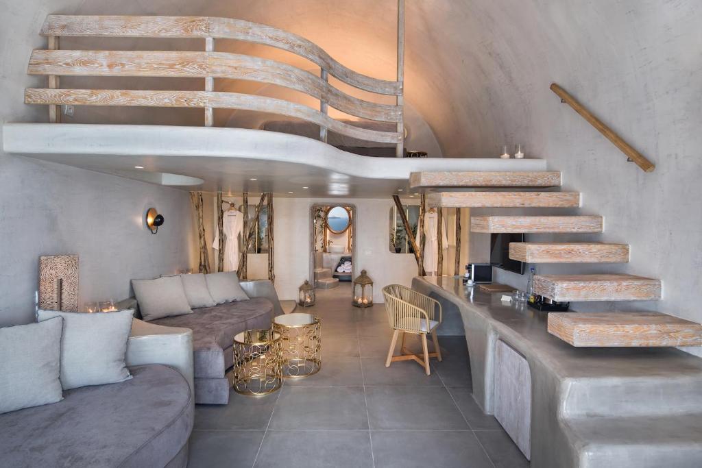 Cave suite with wooden stairs at Athina Luxury Suites in Fira, Santorini