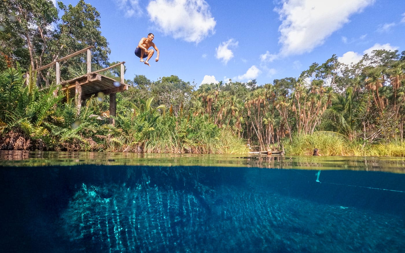 Jumping into blue water at Cenote Cristal Tulum