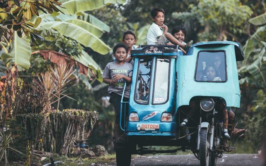 Children riding a tricyle in the philippines