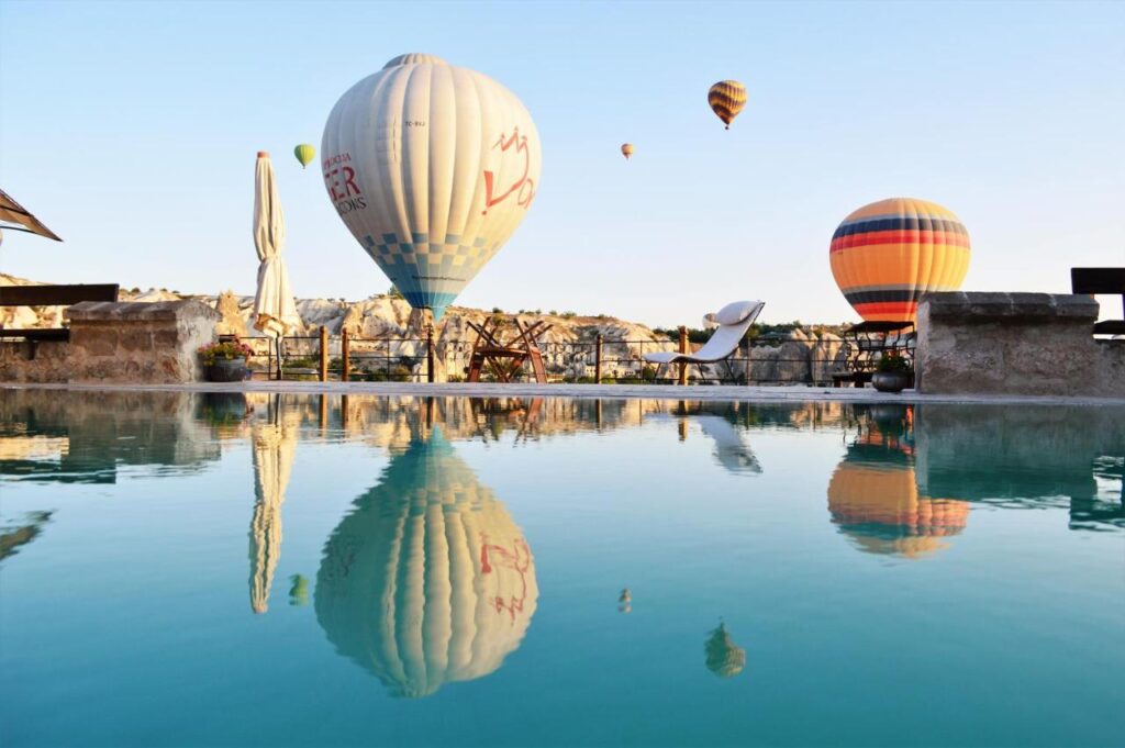 Hot air balloons reflected in rooftop pool, Cappadocia