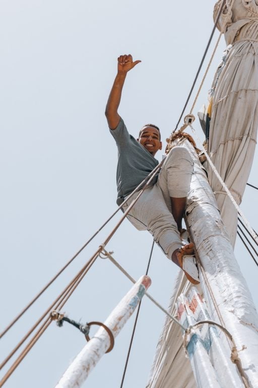 Nubian man climbing the mast