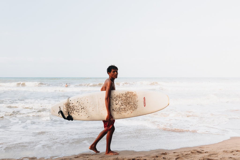 Man with surf board at Palomino beach