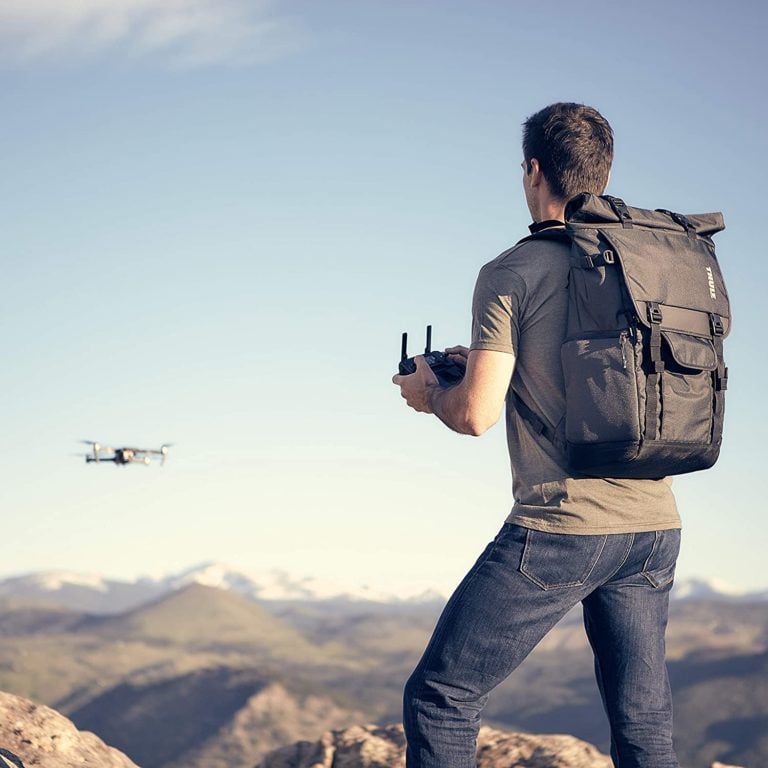 Photographer flying drone with Thule Covert Backpack